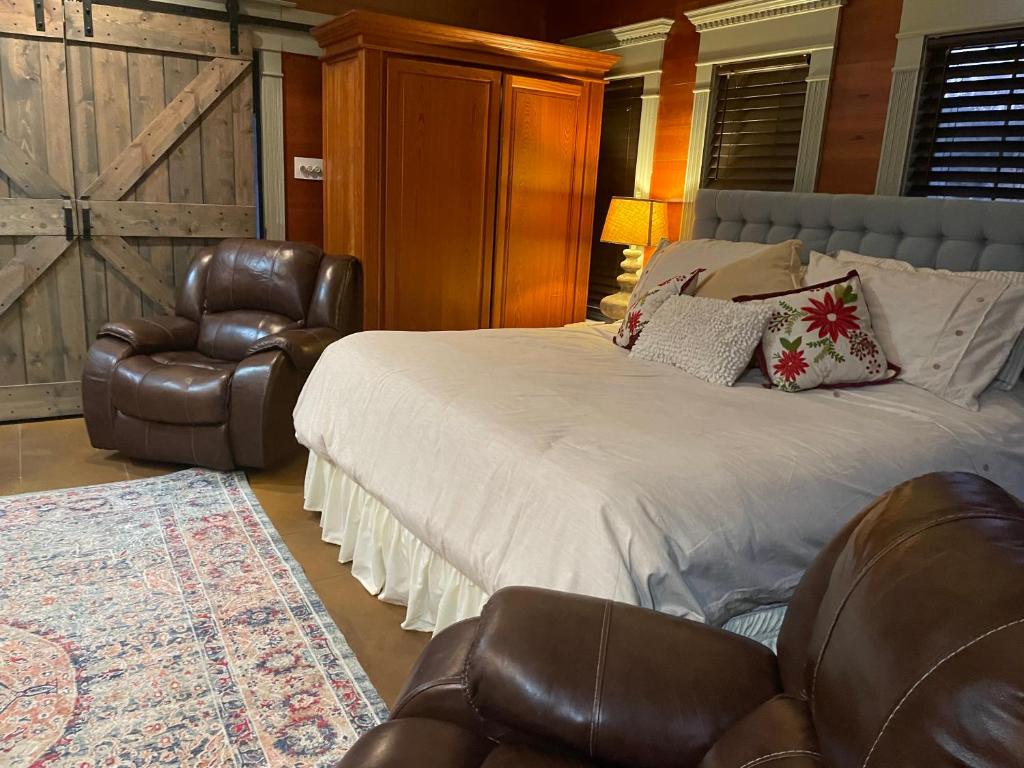1 dormitorio con 1 cama y silla de cuero en Cajun-Get Away, en Breaux Bridge