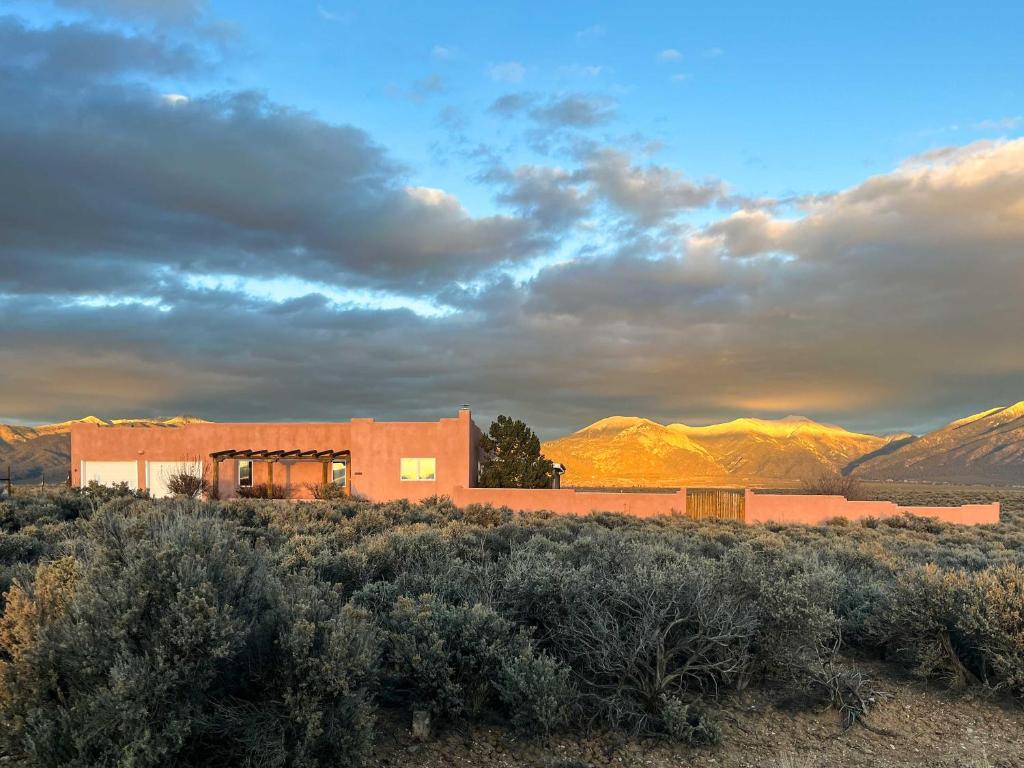 ein Gebäude in der Wüste mit Bergen im Hintergrund in der Unterkunft Southwest Home with 360-Degree Mtn View, Ski Nearby! in El Prado