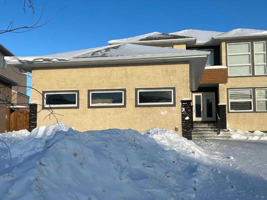a pile of snow in front of a house at Cozy Modern and Lavish 1 Bedroom Basement Suite in Winnipeg