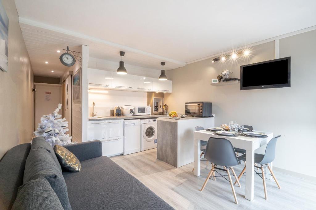 a living room with a couch and a table and a kitchen at L'Espiaube in Saint-Lary-Soulan