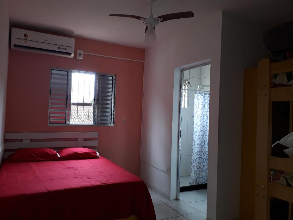 czerwona sypialnia z łóżkiem i oknem w obiekcie Praia da Maria w mieście Ubatuba