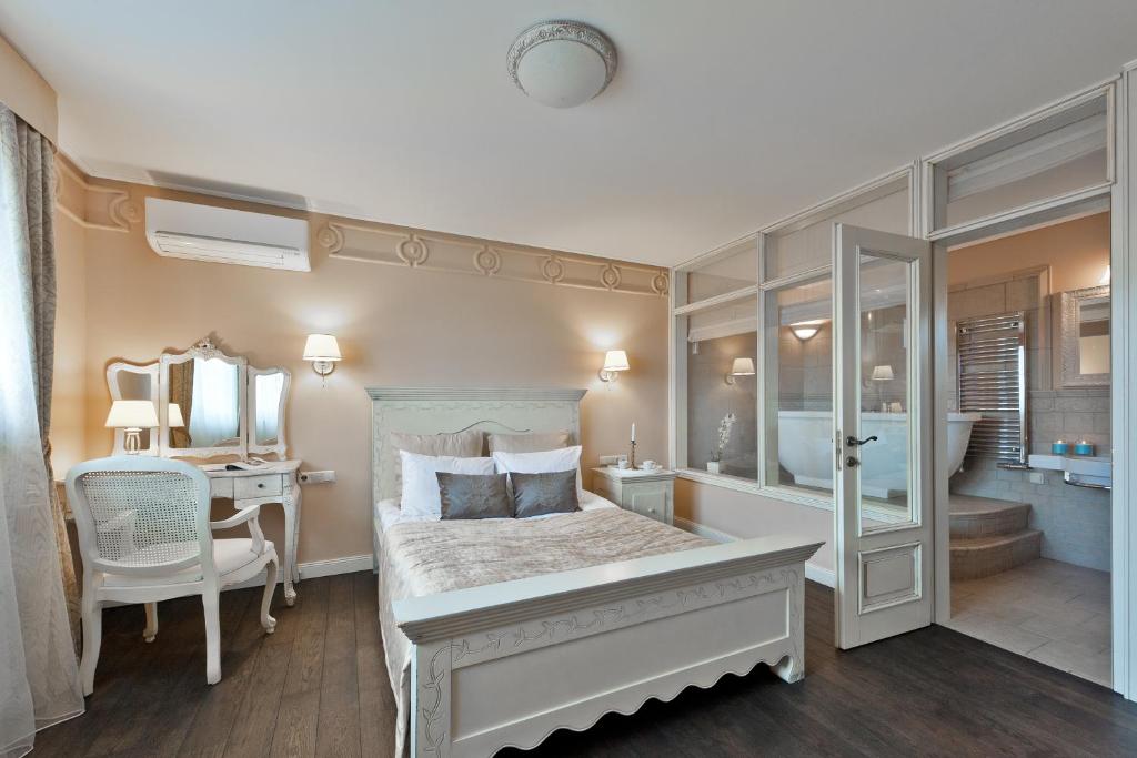 a bedroom with a bed and a desk and a mirror at Viva Trakai in Trakai