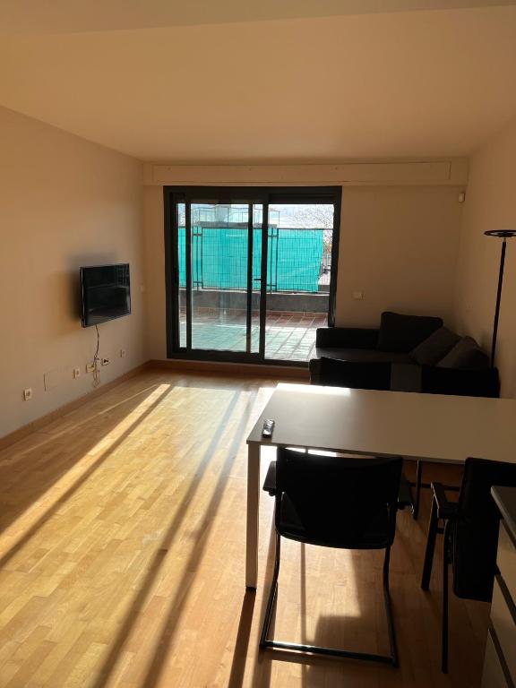 een lege woonkamer met een tafel en een bank bij Loft_Luminoso_Efeso in Madrid
