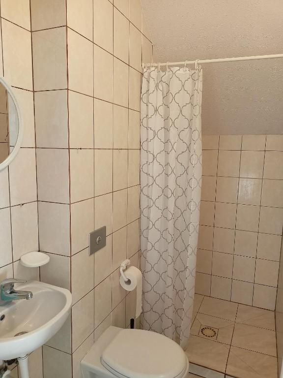 łazienka z toaletą i umywalką w obiekcie Willa Rosa w mieście Kajetany