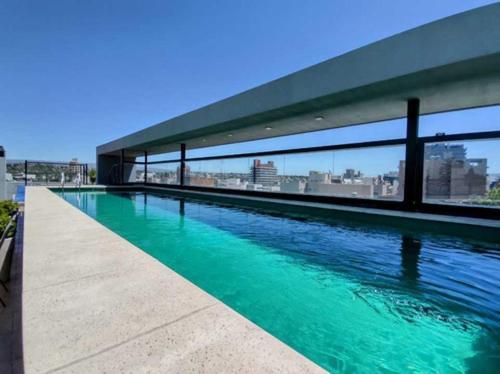 una piscina de agua verde en la parte superior de un edificio en Departamento centrico Villa Carlos Paz en Villa Carlos Paz