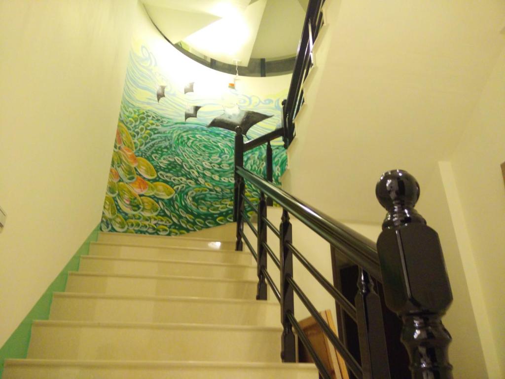 a staircase with a painting on the wall at Dreamily Fish B&B in Magong