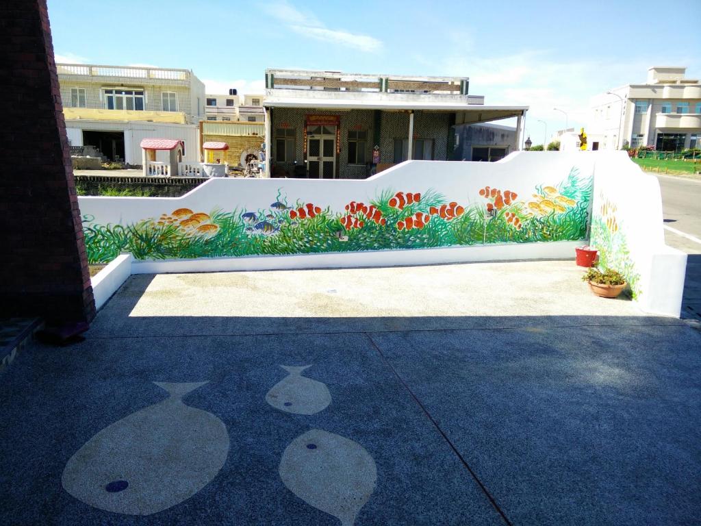 a white wall with a painting of flowers on it at Dreamily Fish B&B in Magong