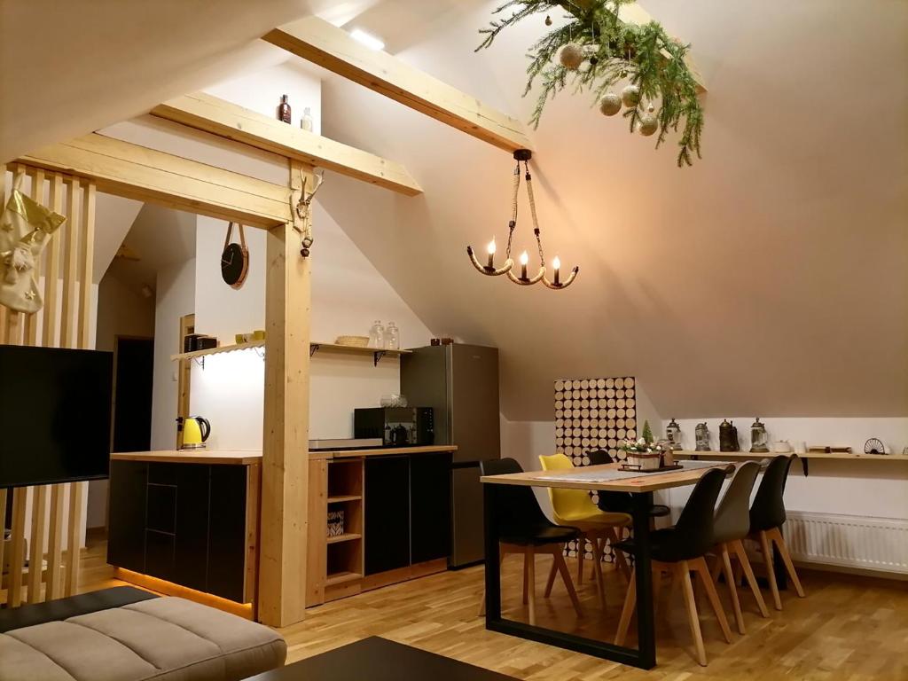 Una cocina y una sala de estar con mesa y sillas. en Willa pod Aniołem # apartament z widokowym tarasem, en Szczawnica