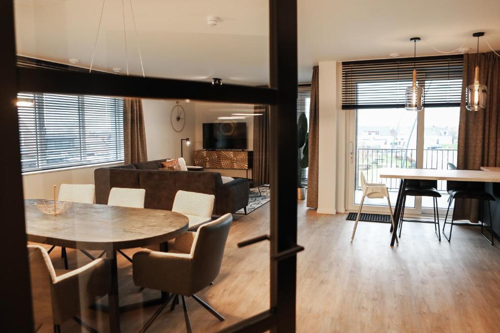 sala de estar y comedor con mesa en Luxe loft appartement in Résidence Marina Kamperland (8 pers.), en Kamperland