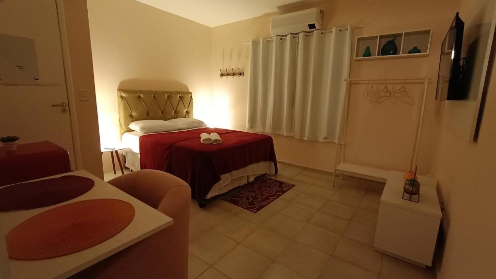 Cette petite chambre comprend un lit et une table rouge. dans l'établissement Suíte Próxima a Praias!, à São Luís