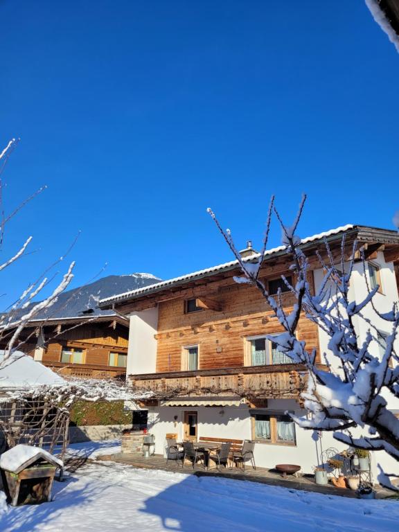 un lodge de esquí en invierno con nieve en el suelo en Haus Carmen en Stumm