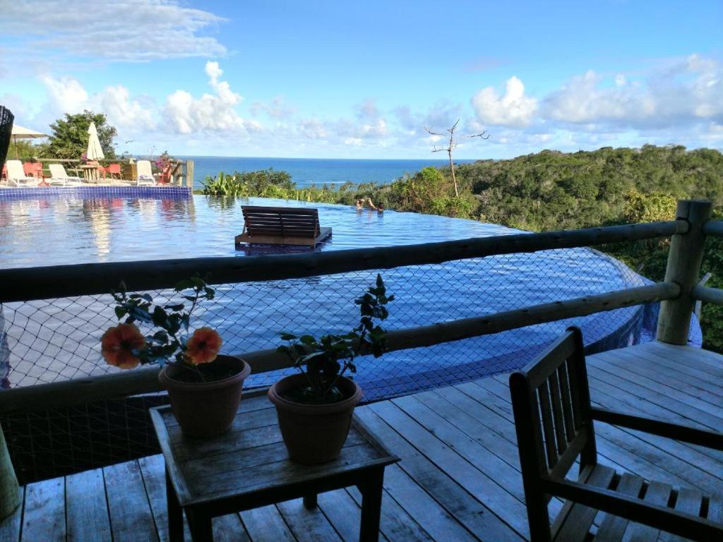 uma vista para uma piscina a partir do deque de uma casa em Villas do Pratagy resort Maceió próximo praia em Maceió