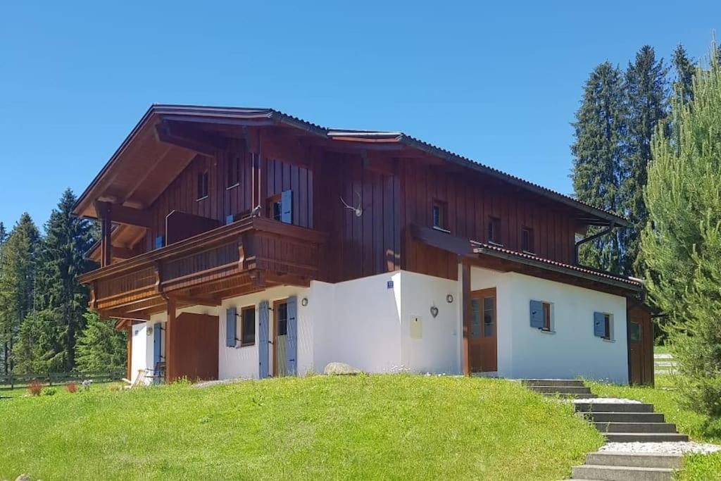 a house on top of a grassy hill at Casa Cubana - Schönes und komfortables Ferienhaus am Waldrand in Lechbruck
