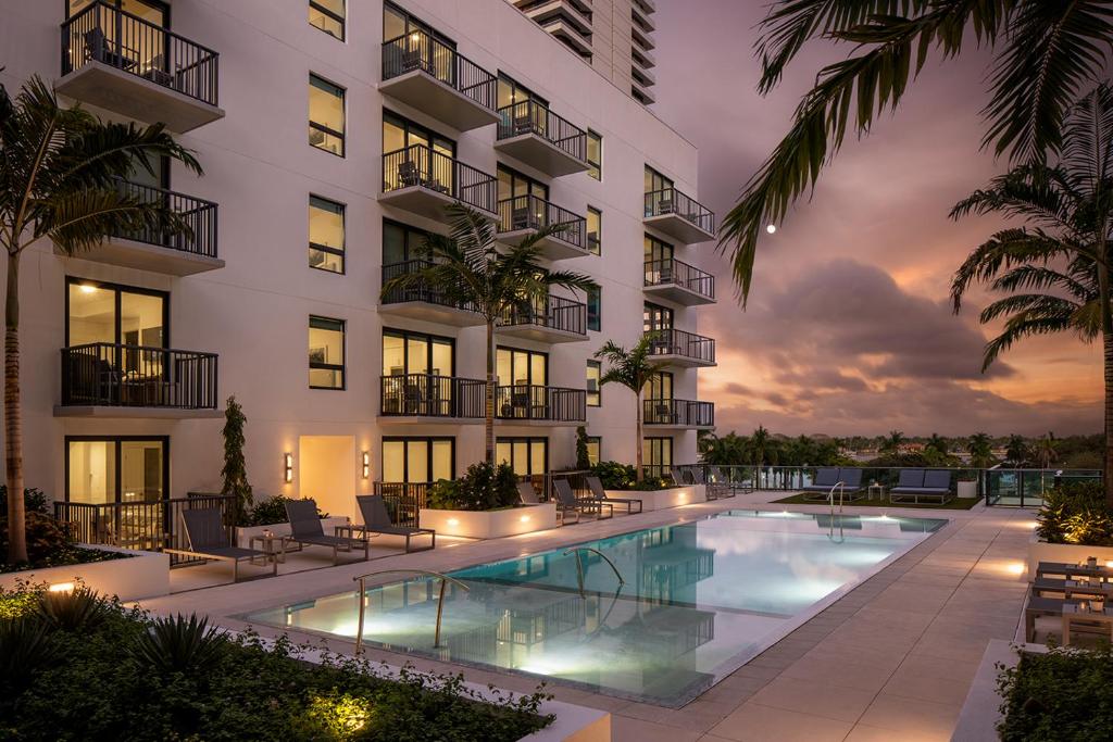 an exterior view of a building with a swimming pool at AKA West Palm in West Palm Beach