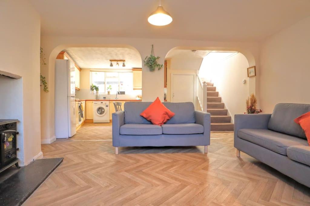 a living room with two blue couches and a fireplace at 4 bed home 3 mins from harbour + sandy beach in Kent