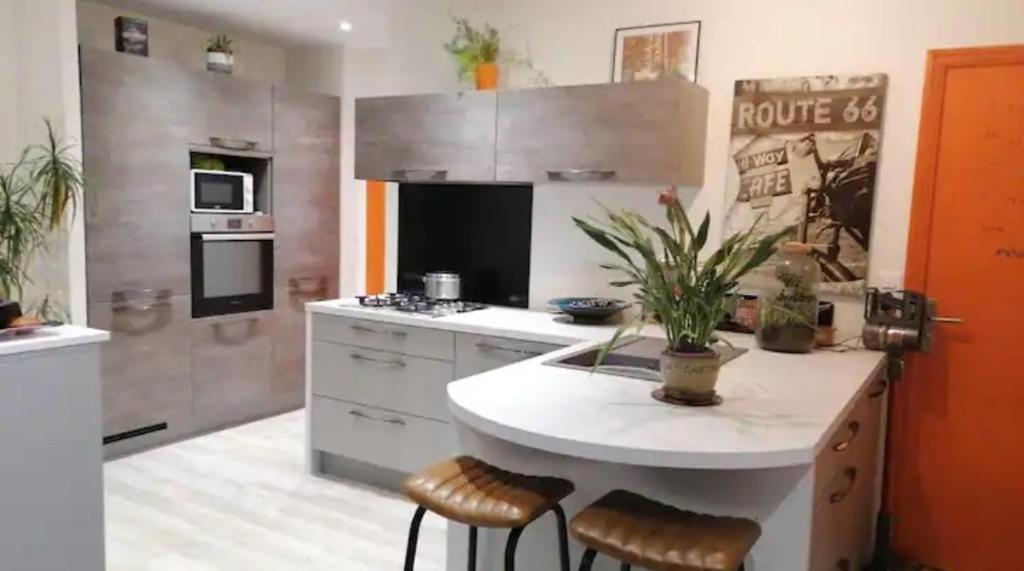 a kitchen with a island with stools in it at Welcome in Pontivy