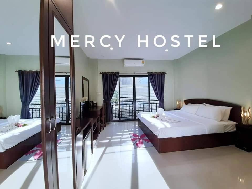 a hotel room with two beds and a mercy hospital sign at Mercy Hostel in Chiang Rai