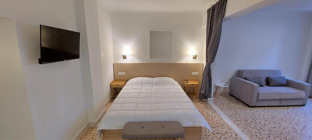 een kamer met een bed, een bank en een tv bij Athens Plaka Family Suites in Athene
