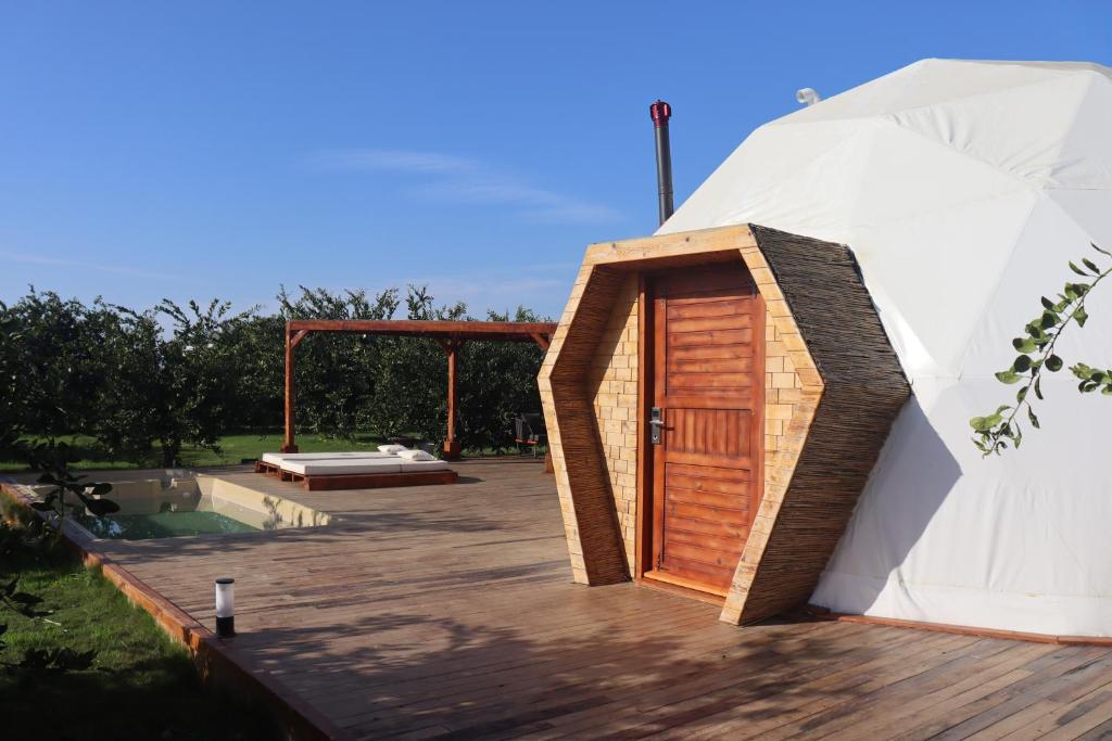 a small house with a wooden door on a deck at Mandalin Glamping in Selçuk