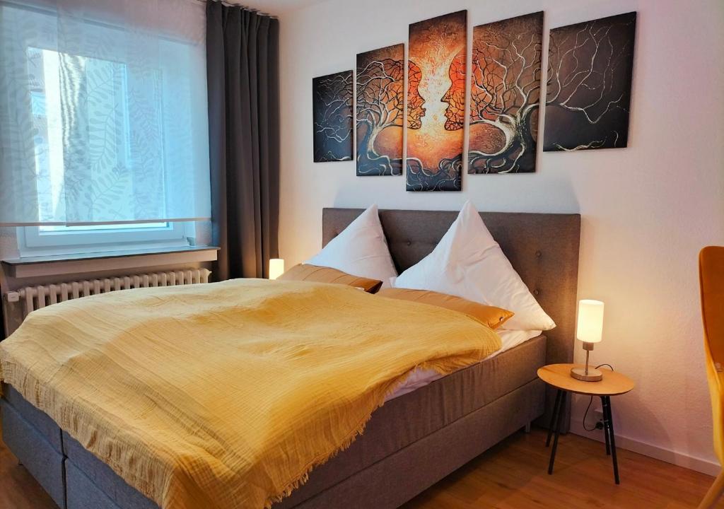 1 dormitorio con 1 cama con 2 cuadros en la pared en Living-Life, Klinik & Messe vor Ort, Wlan, Netflix, en Essen
