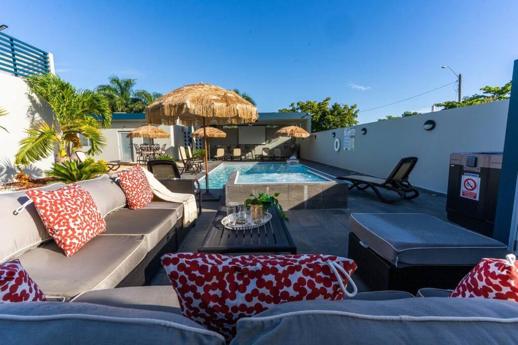 un patio con sofá y piscina en Aquaville Dorado Moderna Villa 1, en Dorado