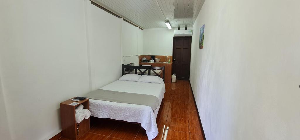 um pequeno quarto com uma cama e uma mesa em Sleep&Go! Cabinas en Siquirres Centro - Rafting tour - Tarifa corporativa Disponible em Siquirres