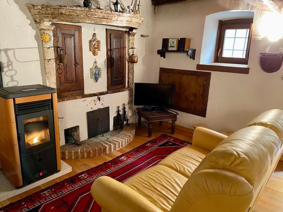 un soggiorno con divano e camino di Casa di montagna nel borgo di Rocca di Mezzo a Rocca di Mezzo