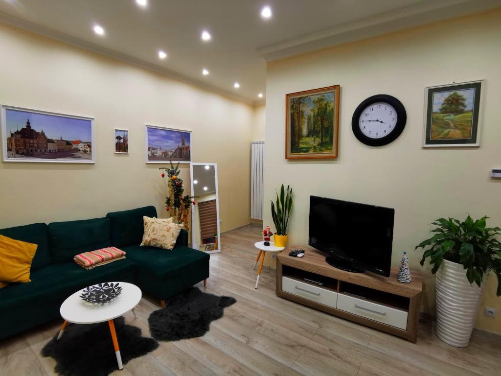 sala de estar con sofá verde y TV en Apartament - Przy Rynku en Tarnowskie Góry