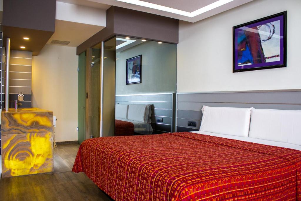 a bedroom with a large bed with a red blanket at HOTEL MIRAMAR in Mexico City