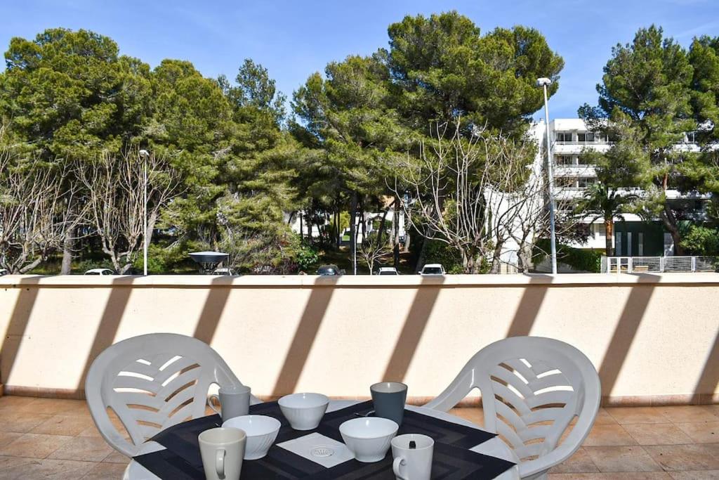 una mesa y dos sillas con tazones y tazas. en Apartamento Maria,Bahía de Alcudia en Alcúdia