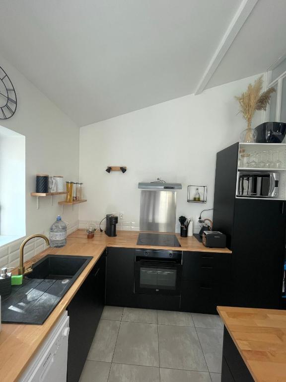 une cuisine avec un évier et une cuisinière four supérieur dans l'établissement Maisonnette, à Sainte-Soulle