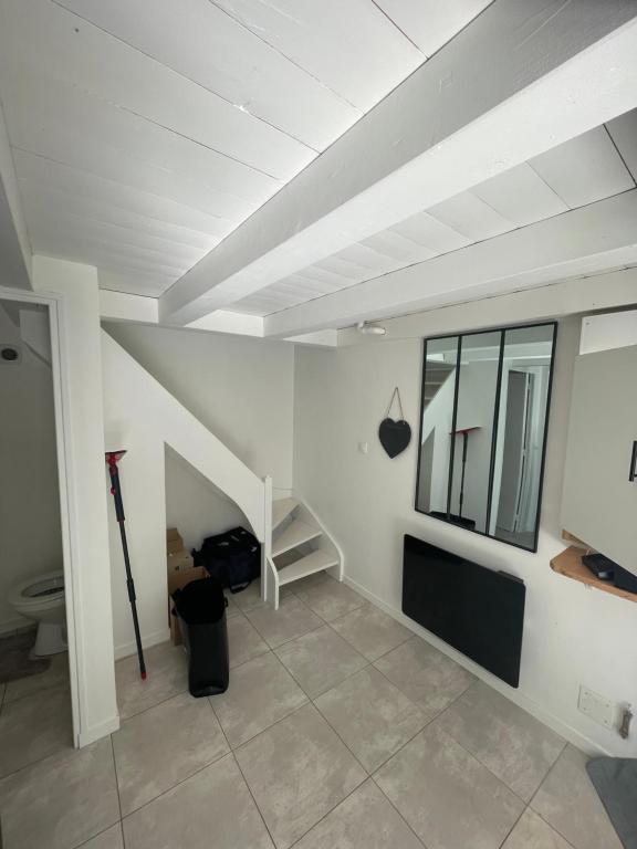 Habitación blanca con escalera y ventana en Maisonnette en Sainte-Soulle