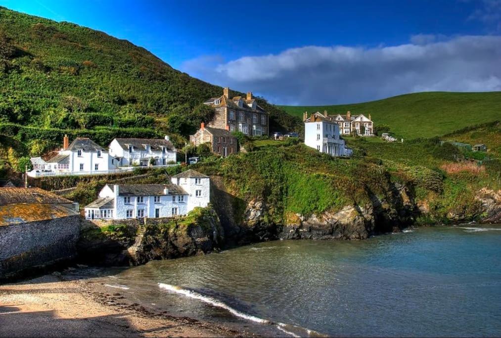 a group of houses on a hill next to the water at Folly 1, Port Isaac Bay Holidays in Port Isaac