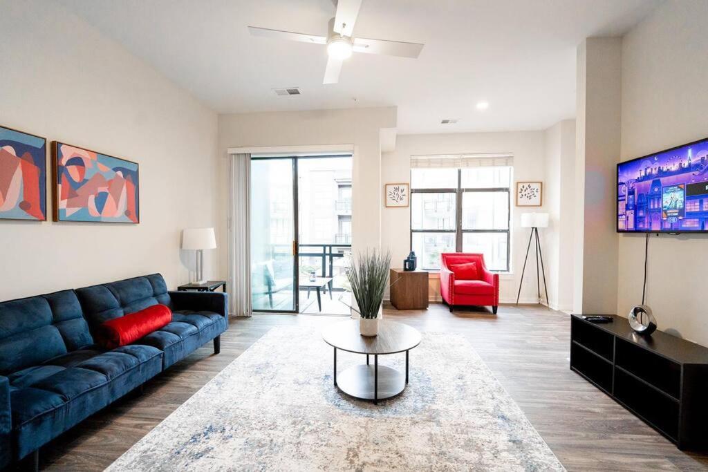 a living room with a blue couch and a red chair at Luxury Apartment WiFi, Gym, Pool, Shops & Food! Unit 329 in Charlotte