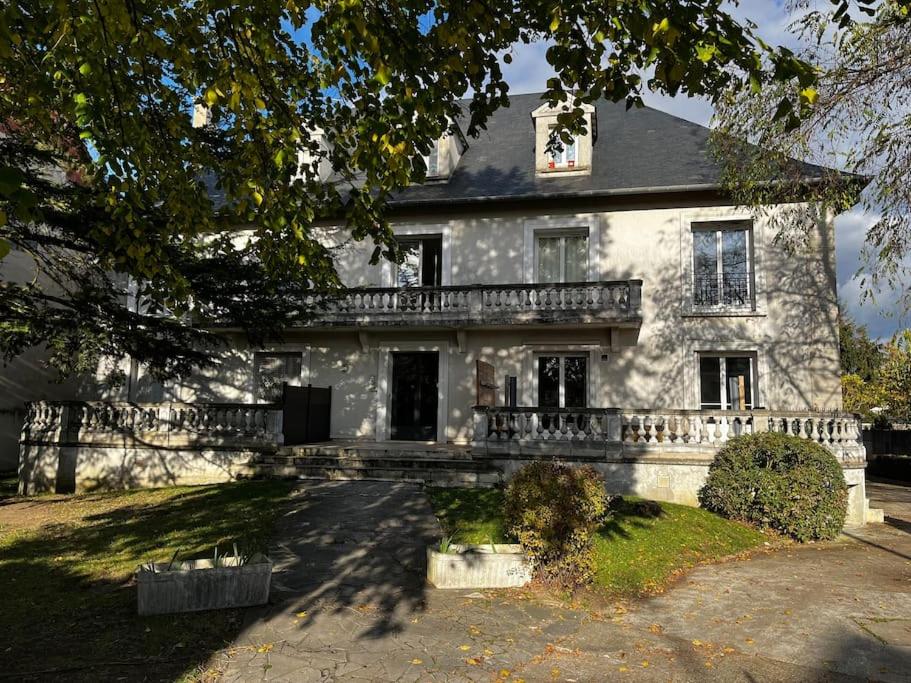 a large white stone house with a balcony at Appartement Proche de Disneyland & Paris in Noisy-le-Grand