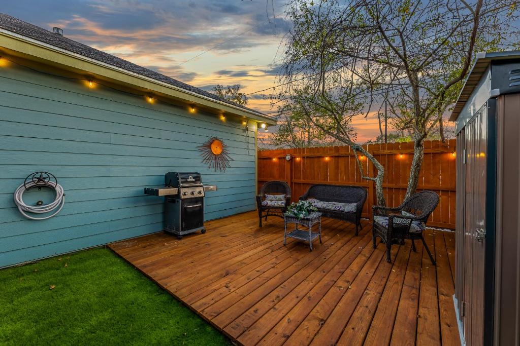 a deck with a grill and chairs on a house at Little Blue House on Lonnie Lane in Houston