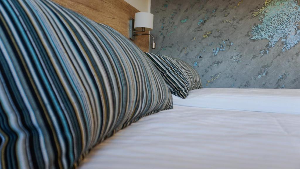 Una cama con dos almohadas encima. en Motel Arctic Wind en Vogar
