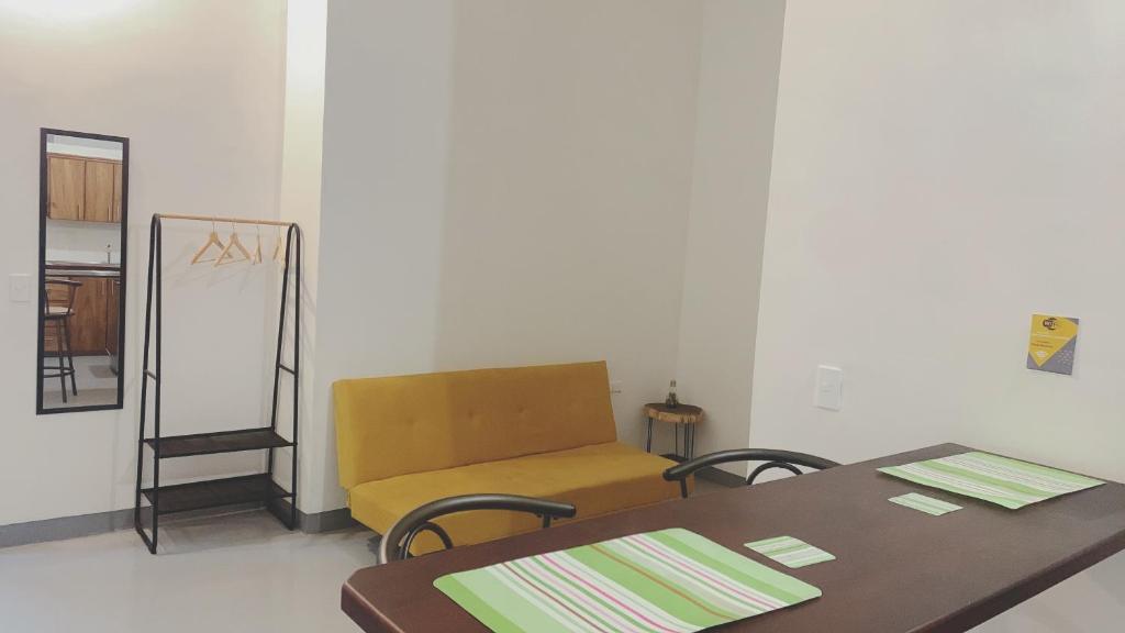 a room with two tables and a yellow couch at Aloja-T en Apartamento amoblado 6 con balcón Ciudad Bolivar in Ciudad Bolívar