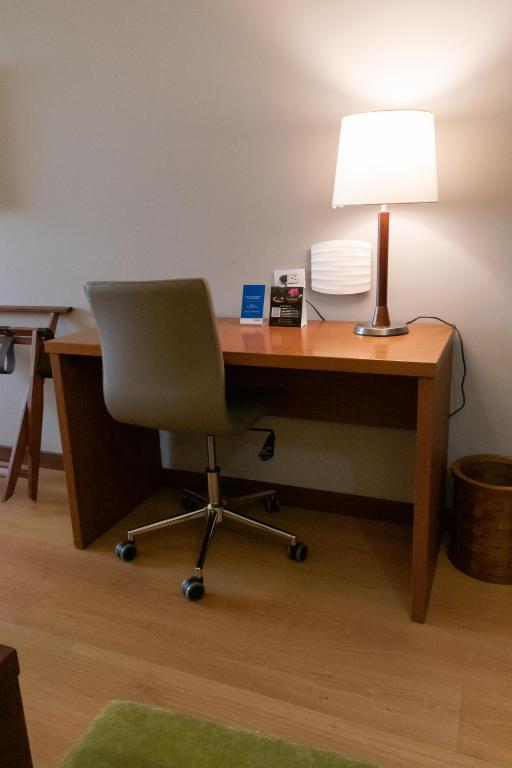 an office with a desk with a lamp and a chair at Hotel Habitel Select in Bogotá