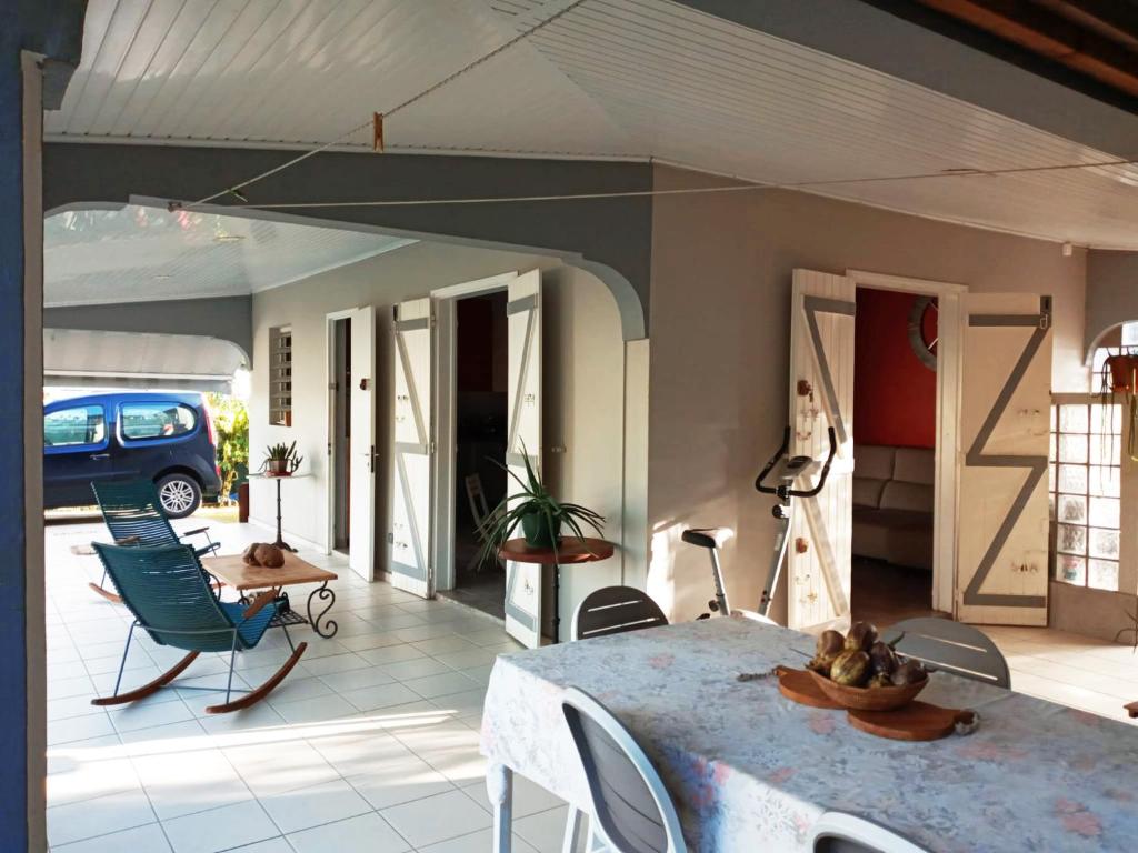 a patio with a table and chairs in a room at Villa SUNESIS Lamentin in Lamentin