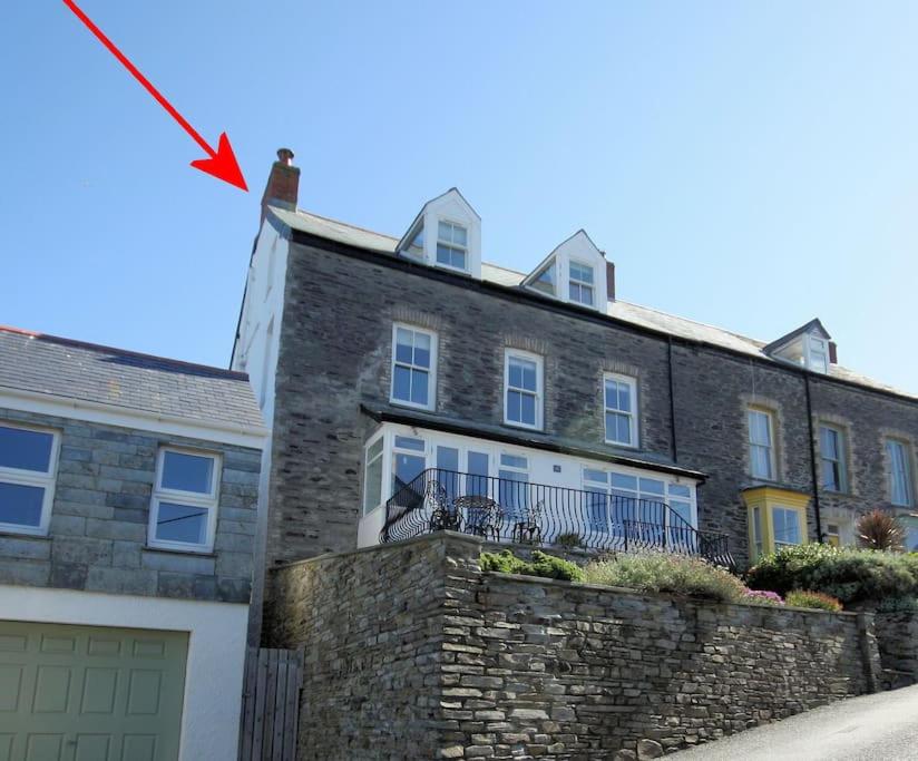 a brick house with a flag flying in front of it at Upper Deck, Port Isaac Bay Holidays in Port Isaac