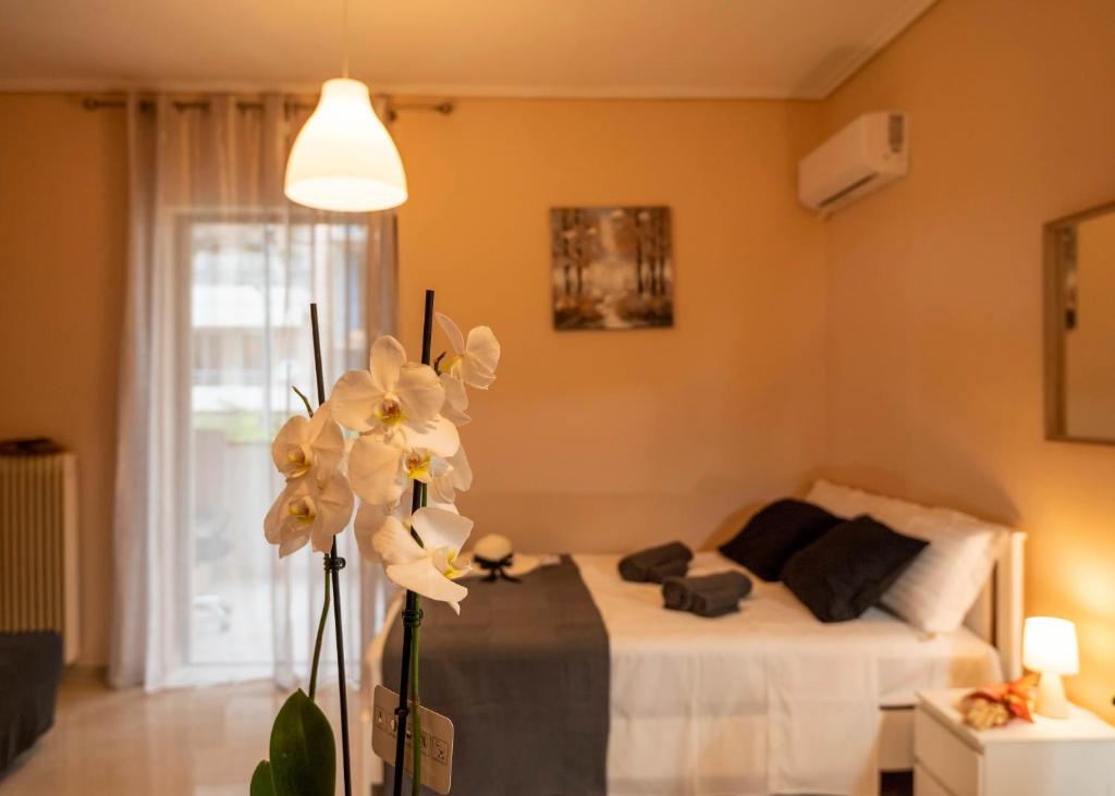 una camera con un letto e un fiore in primo piano di COZY STUDIO in RETHYMNO TOWN a Rethymno