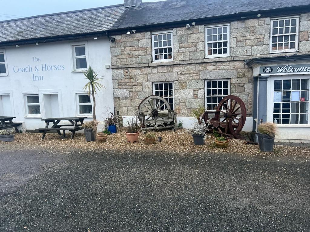 a stone building with plants in front of it at Coach and Horses INN in Penzance