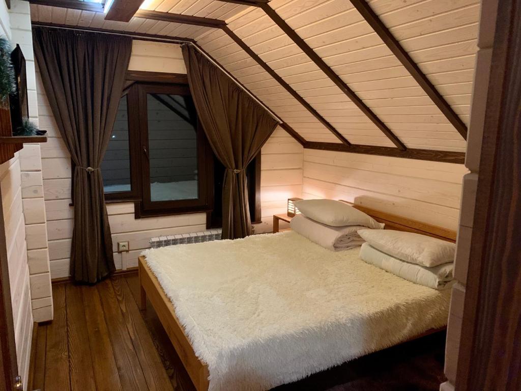 Un dormitorio con una cama con almohadas. en Еко будинок в горах, en Verkhniy Bystryy