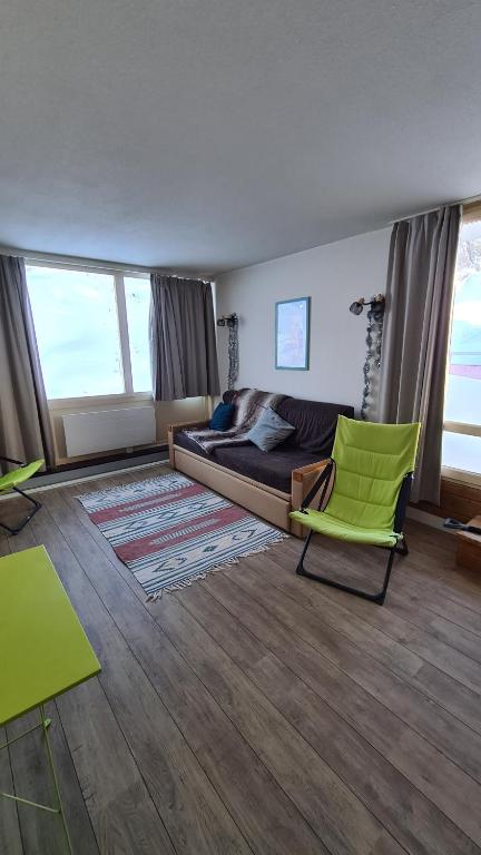 sala de estar con cama y silla verde en Appartements Bozeman en La Mongie