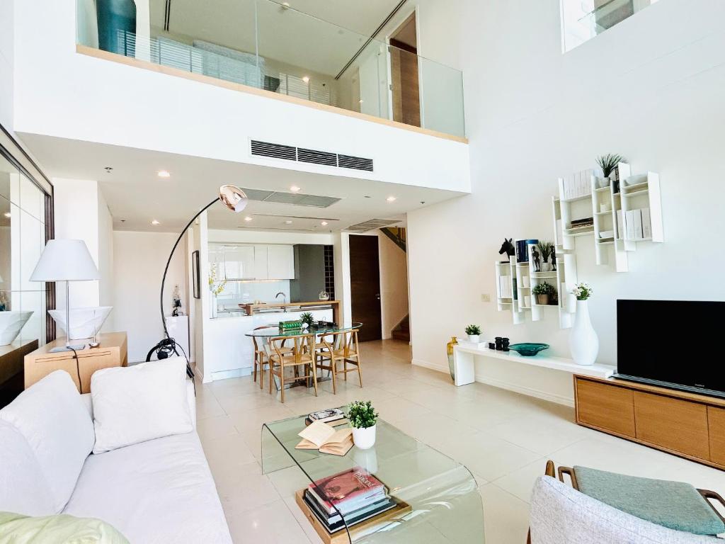 a living room with a white couch and a glass table at The river luxury two bedrooms in Bangkok