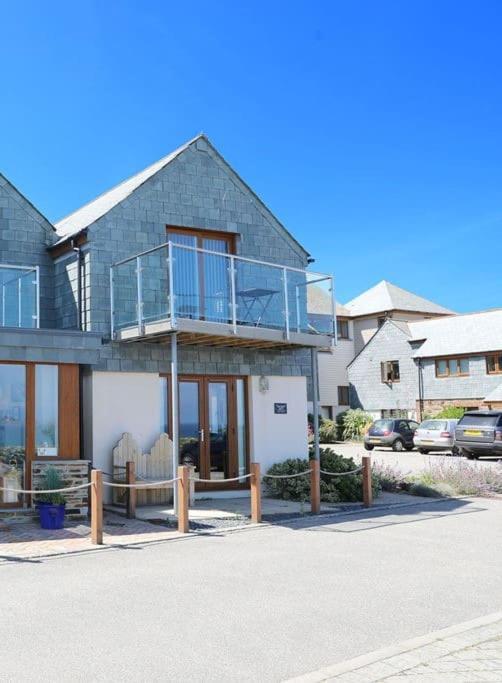 a large house with a balcony on a street at Sea Gem, Port Isaac Bay Holidays in Port Isaac