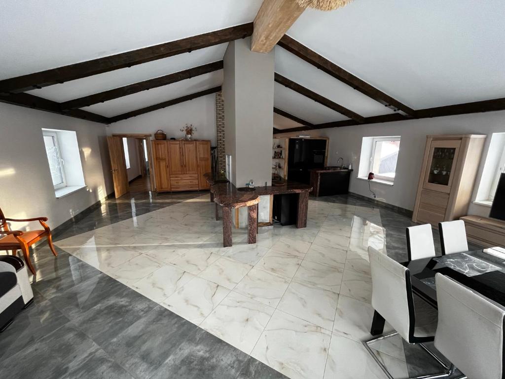 ein großes Wohnzimmer mit einem Tisch und Stühlen in der Unterkunft Lauku rezidence in Cēsis