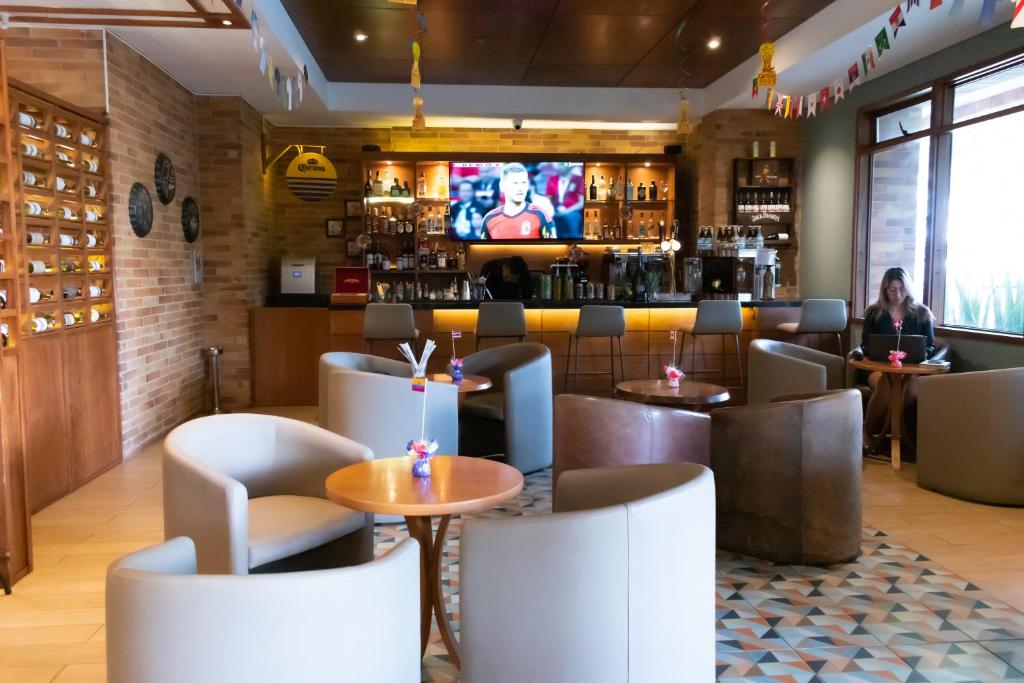 a restaurant with a bar with a tv in the background at Hotel Habitel Select in Bogotá