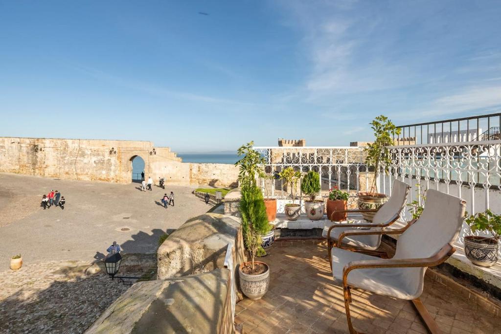 a balcony with two chairs and a view of the ocean at Dar BAB HAHA Petite Maison à la Marocaine in Tangier